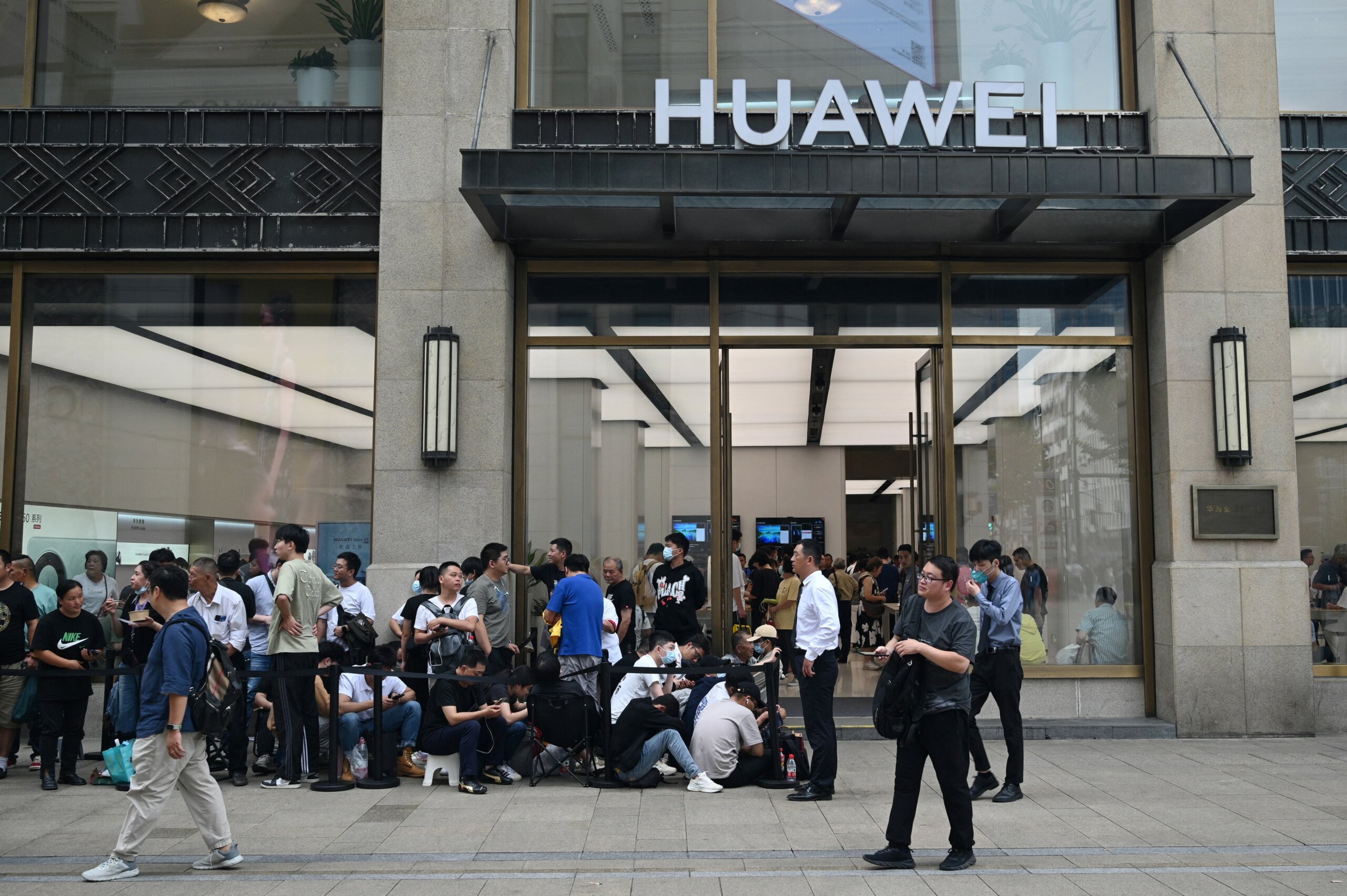 Sales of Huawei smartphones in China grew 37% YoY, commanding a 12.9% market share in the quarter while Apple declined. Photo: People queue up for hours outside Huaweis flagship store in Shanghai on September 25, 2023, hoping to be able to buy the tech giant's latest Mate 60 Pro mobile phone. (Photo by REBECCA BAILEY / AFP)