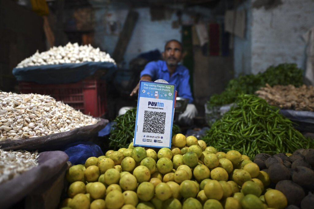 A vegetable vendor with a QR code of the Indian cellphone-based digital payment platform Paytm.