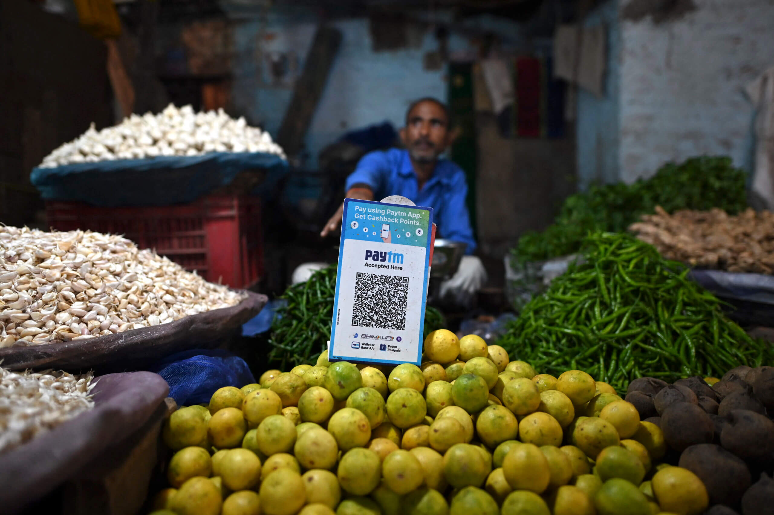 A vegetable vendor with a QR code of the Indian cellphone-based digital payment platform Paytm.